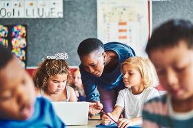 Teacher and young students on computers