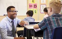 Image of smiling African American teacher with student