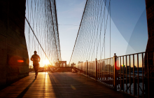 Man running on a bridge at sunrise