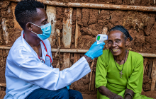 男医生采取高级女人温度在偏远村庄,东非