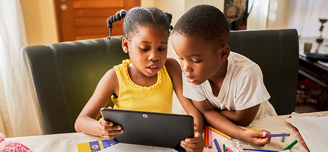 小男孩和小女孩一起看平板电脑的图片
